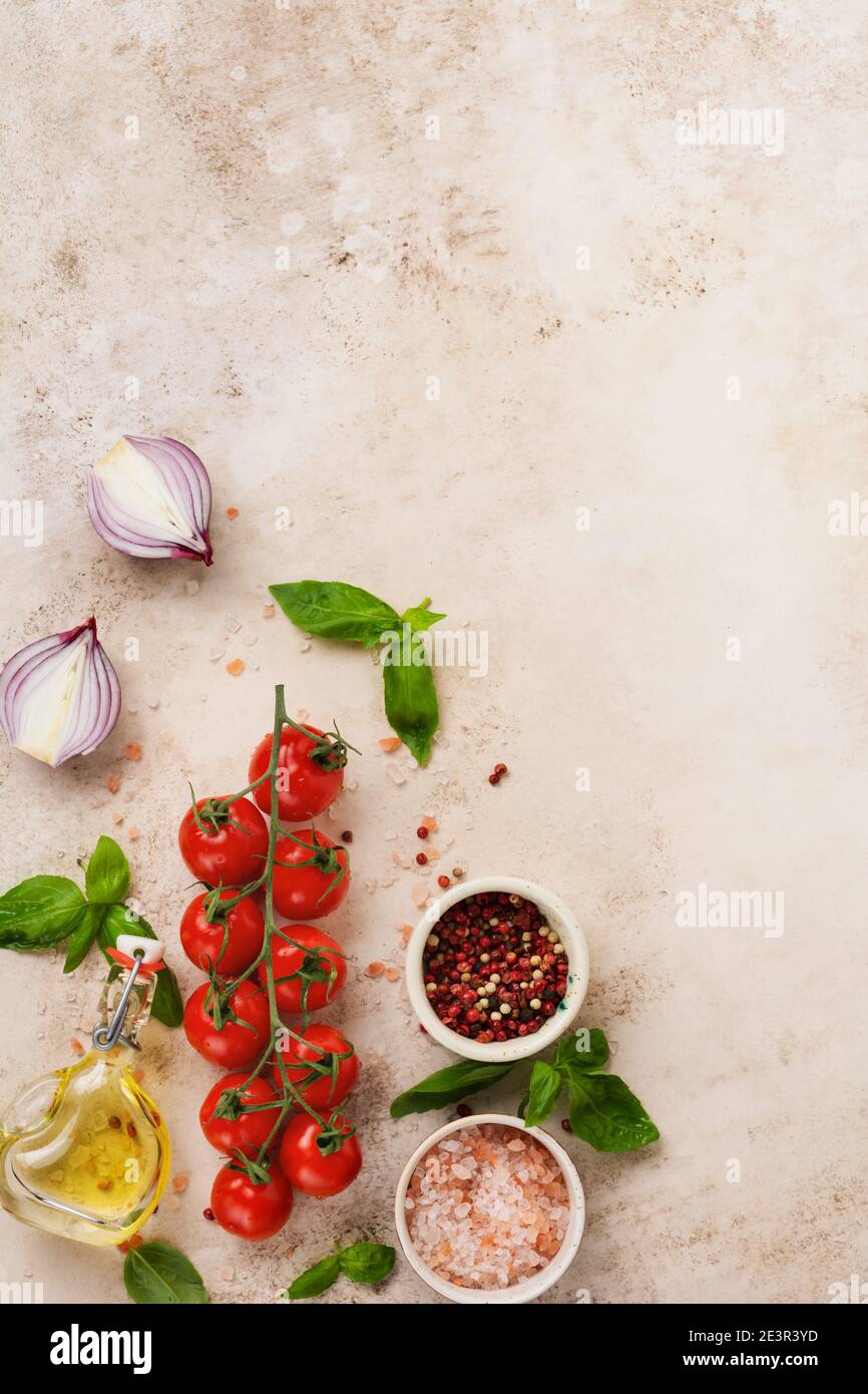 Rohe Orecchiette mit Parmesankäse und Tomaten, Basilikum, Knoblauch und Öl auf hellem Hintergrund mit Pfeffer auf hellbraunem Hintergrund. Traditionell eingetellt Stockfoto