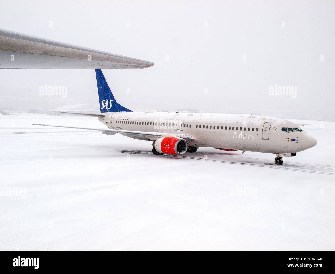 Ein SAS-Flugzeug auf der Piste im Schnee am Flughafen Oslo, Norwegen Stockfoto