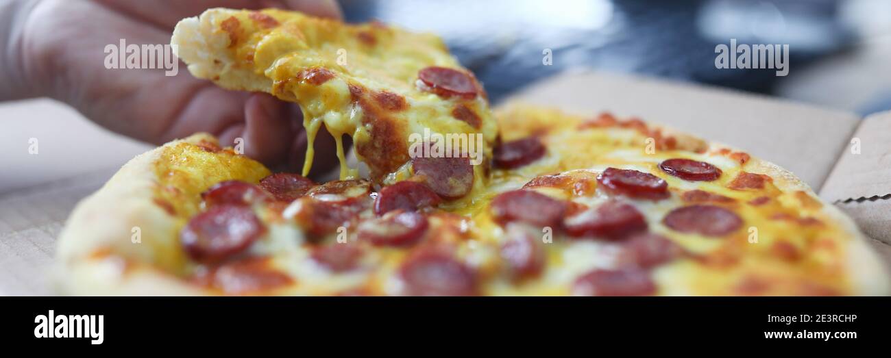 Mann nimmt Pizzablecken mit Wurst Nahaufnahme Stockfoto