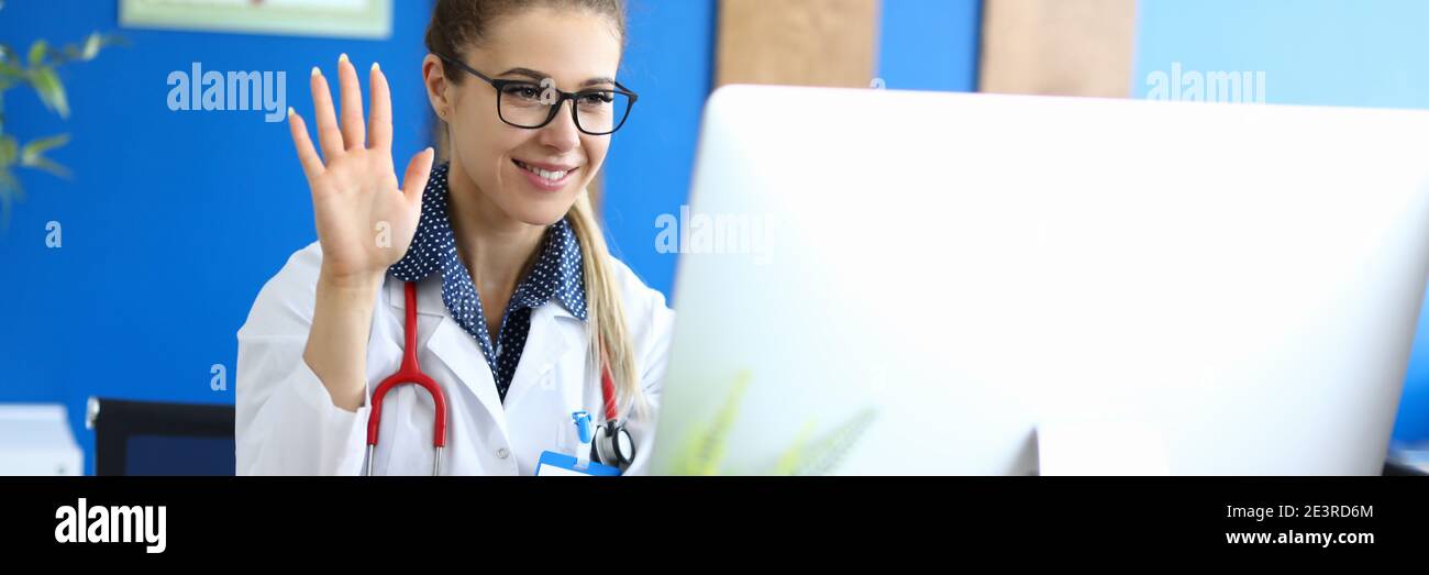 Lächelnde Frau Arzt begrüßt den Patienten online Stockfoto
