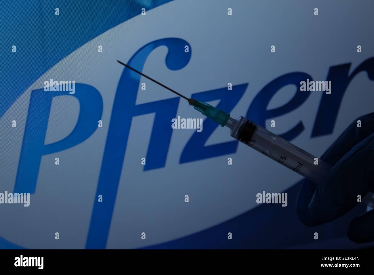 Covid-19 Impfstoffkonzept. Spritzennadel, Pfizer Logo auf dem Hintergrund. Impfkonzept für Coronaviren. Stockfoto