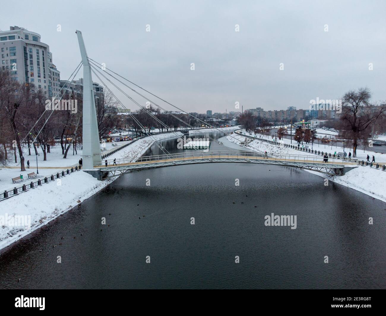 Fußgängerbrücke über den Fluss Charkiw (Mist Zakokhanykh), beliebter Ort für Paare. Winter verschneiten Luft Stadtzentrum Erholungspark Stockfoto