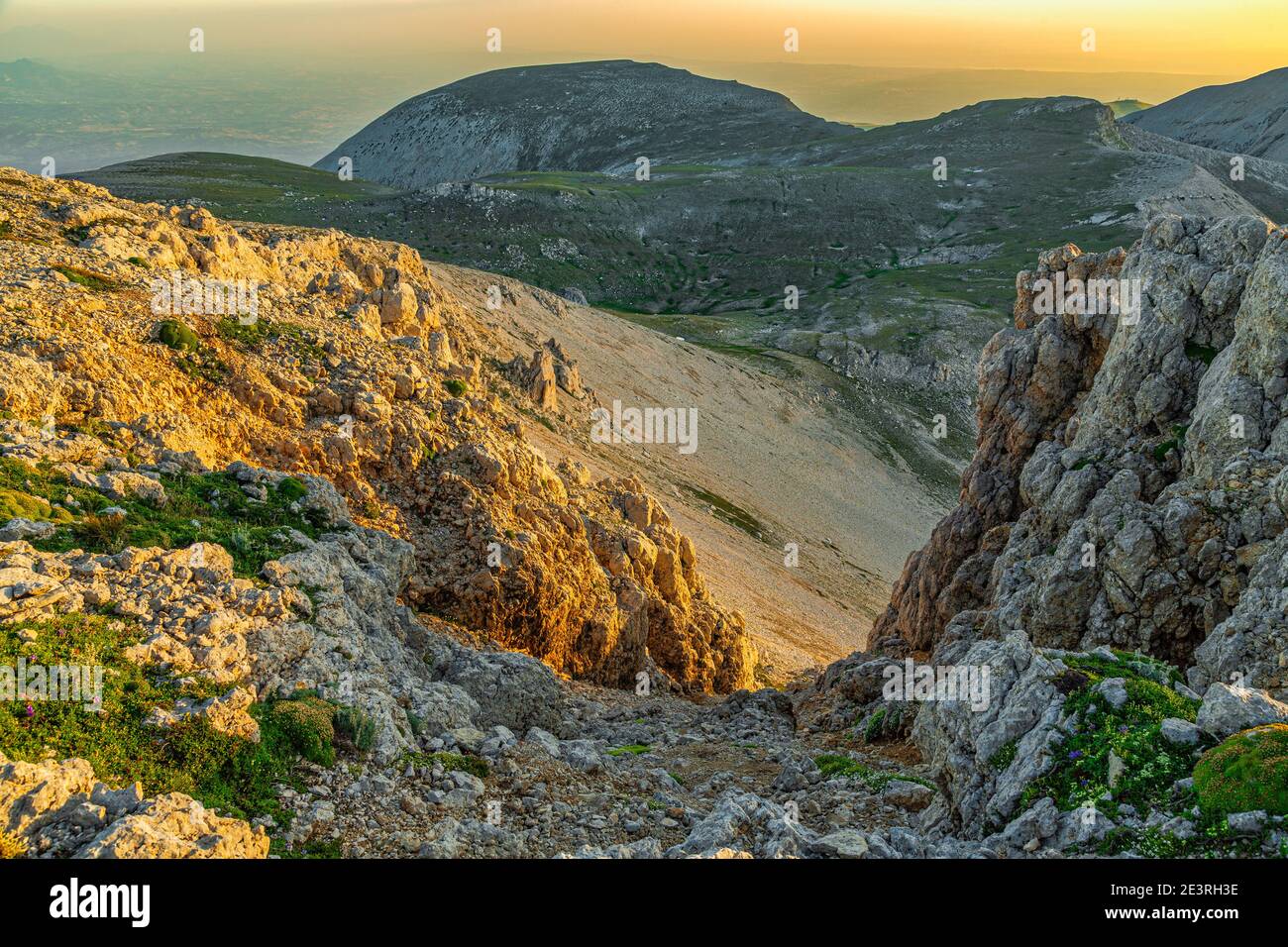 Felsen mit Blick auf das Cannella-Tal, beleuchtet vom ersten Licht der Dämmerung. Im Hintergrund die Spitze des Tre Portoni. Maiella Nationalpark Stockfoto