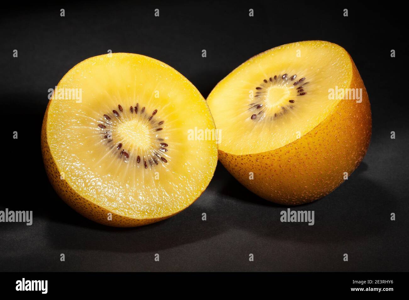 Geschnittene goldene Kiwi auf schwarzem Hintergrund Stockfoto