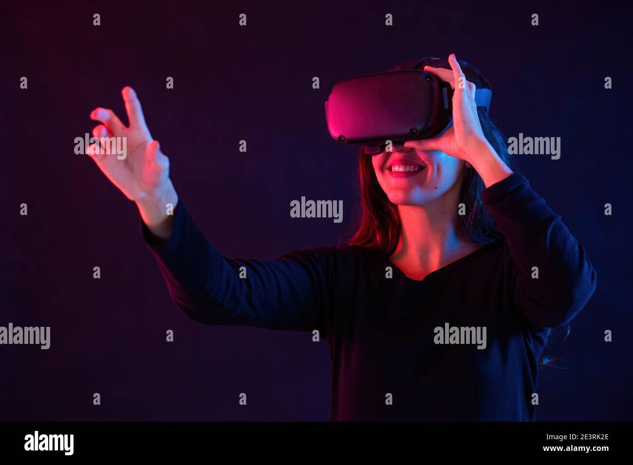 Lächelnde Frau mit Headset, die in der virtuellen Realität interagiert Stockfoto