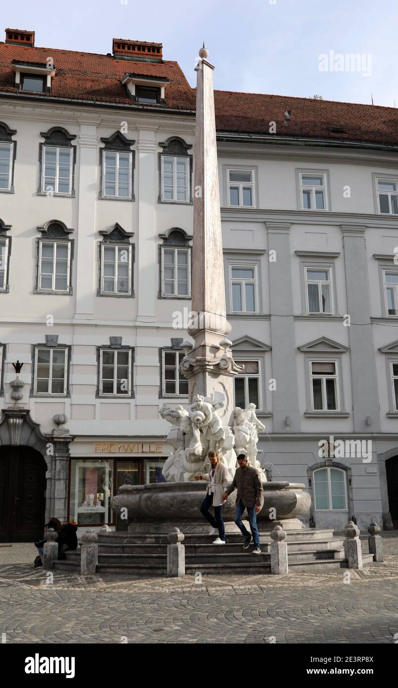 Touristen am berühmten Brunnen der drei Flüsse von Krain In Ljubljana, die als Robba-Brunnen bekannt ist Stockfoto
