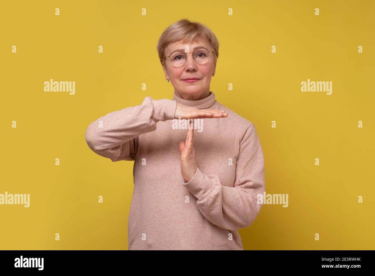 Seriöse Frau zeigt Auszeit Geste, brauchen mehr Zeit für die Arbeit, um Pause bitten. Studioaufnahme Stockfoto