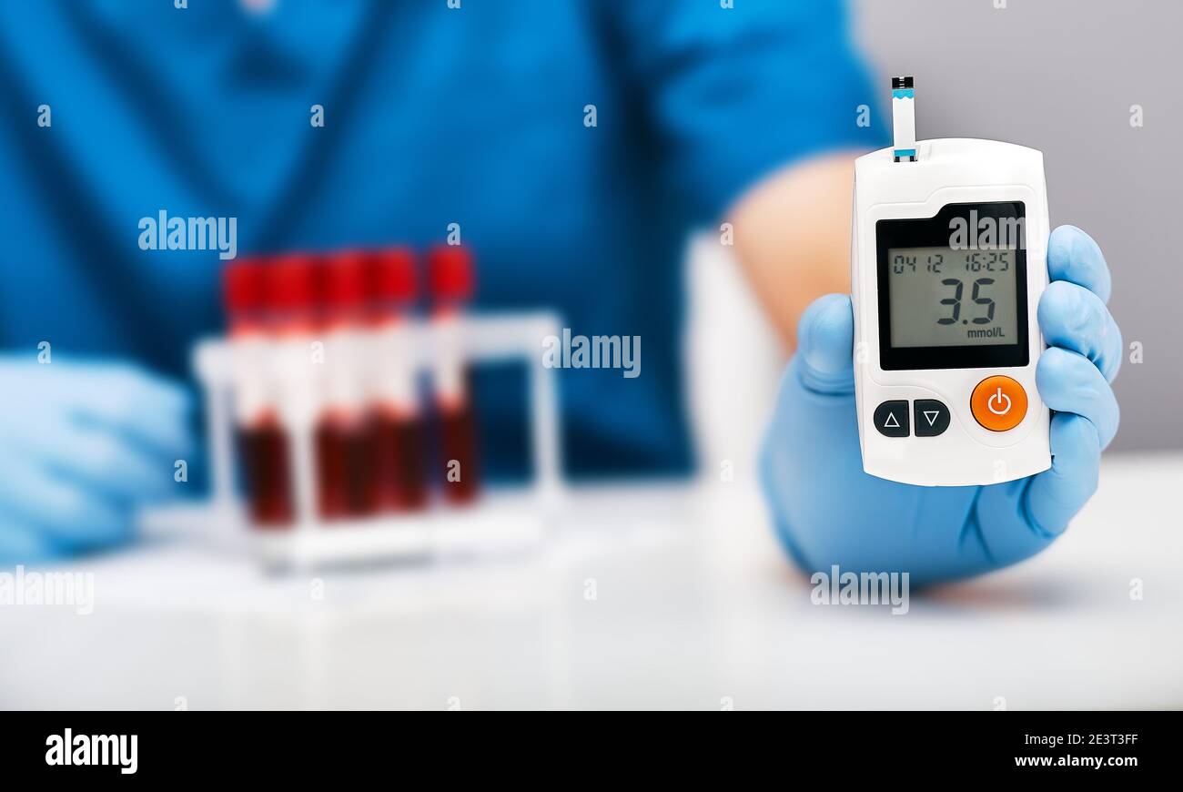 Arzt, der den Blutzuckerspiegel eines Diabetikers mit einem Glukometer überprüft Stockfoto