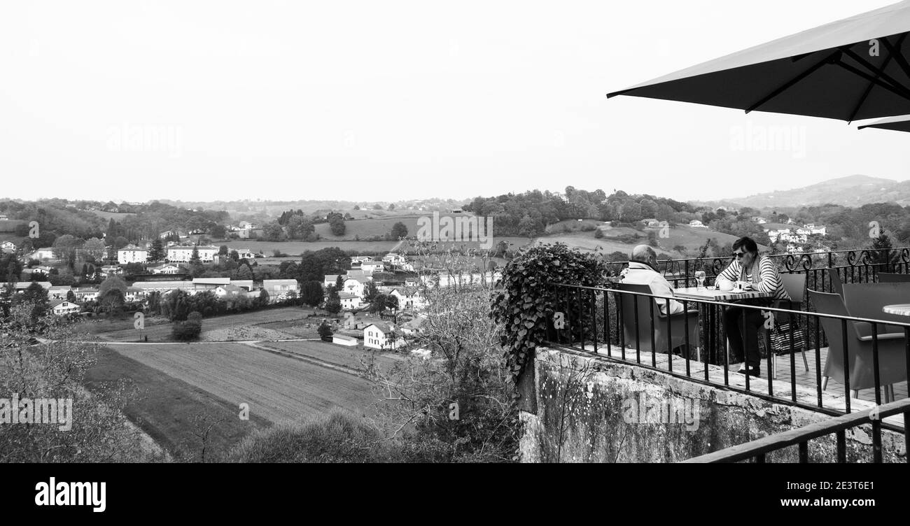 CAMBO-LES-BAINS, FRANKREICH - AVRIL 19, 2018: Seniorenpaar, das sich im Café mit Talblick in Cambo-les-Bains (charmanter Kurort) entspannt. Schwarzweißfoto Stockfoto