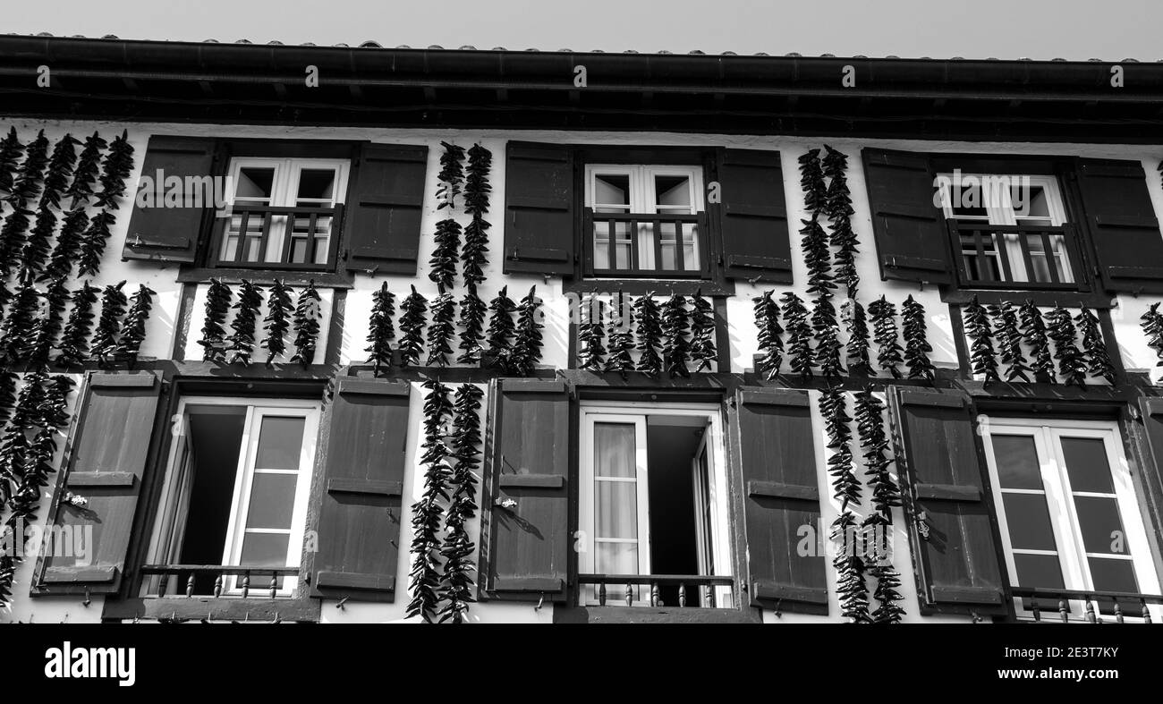 Traditionelles baskisches Haus mit Espelette-Paprika-Girlanden, die an der Sonne trocknen. Espelette, Frankreich. Historisches Foto in Schwarzweiß Stockfoto