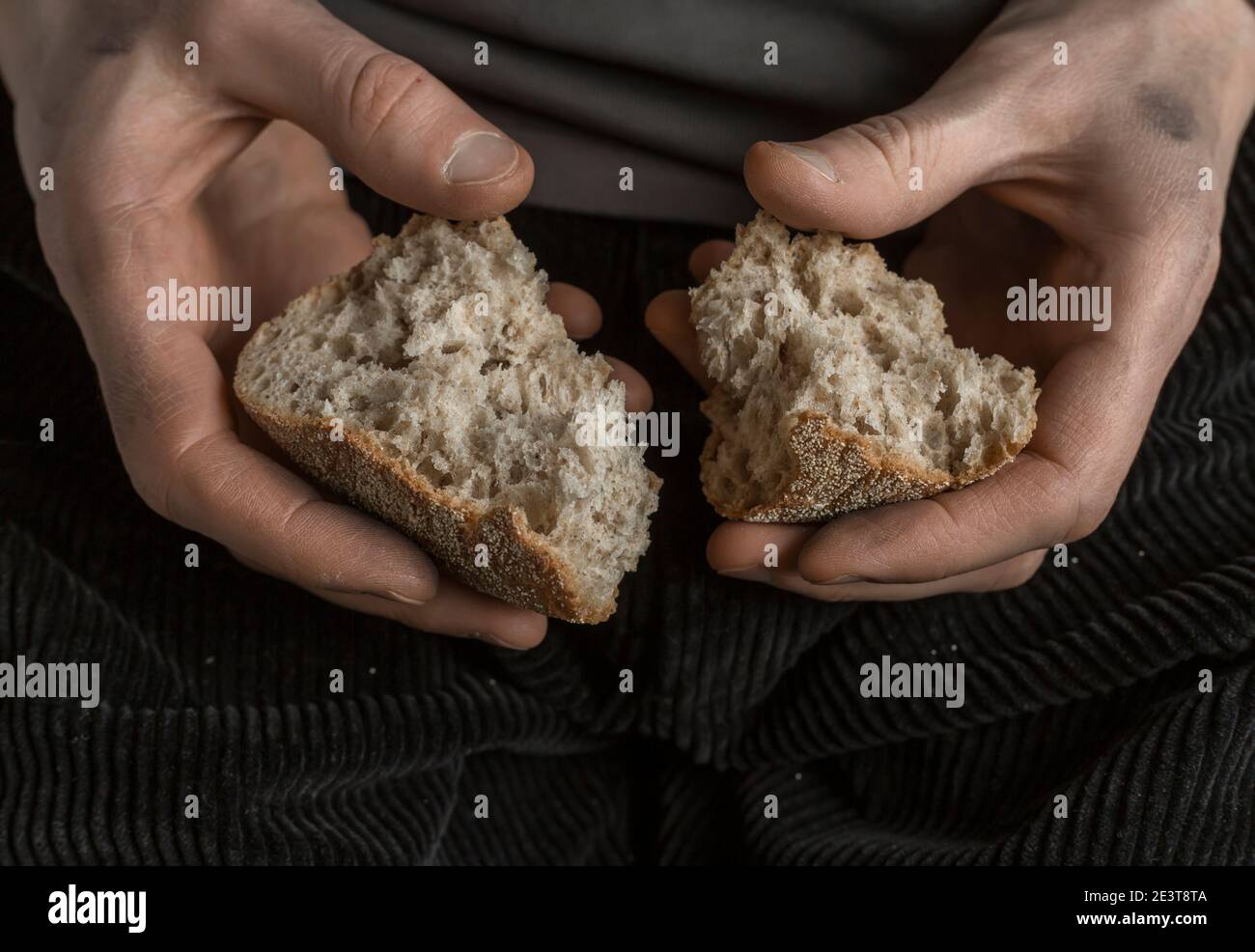 Hunger-Konzept. Brotscheiben in den Händen eines Mannes. Armut. Stockfoto