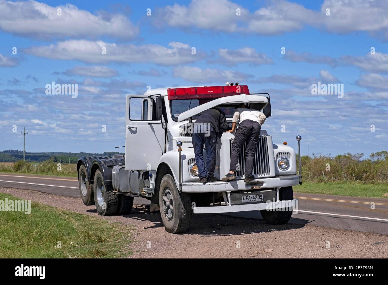 Zwei uruguayische Männer, Fahrer und Mechaniker reparieren zerbrochenen LKW / LKW entlang desolate Straße im ländlichen Uruguay Stockfoto