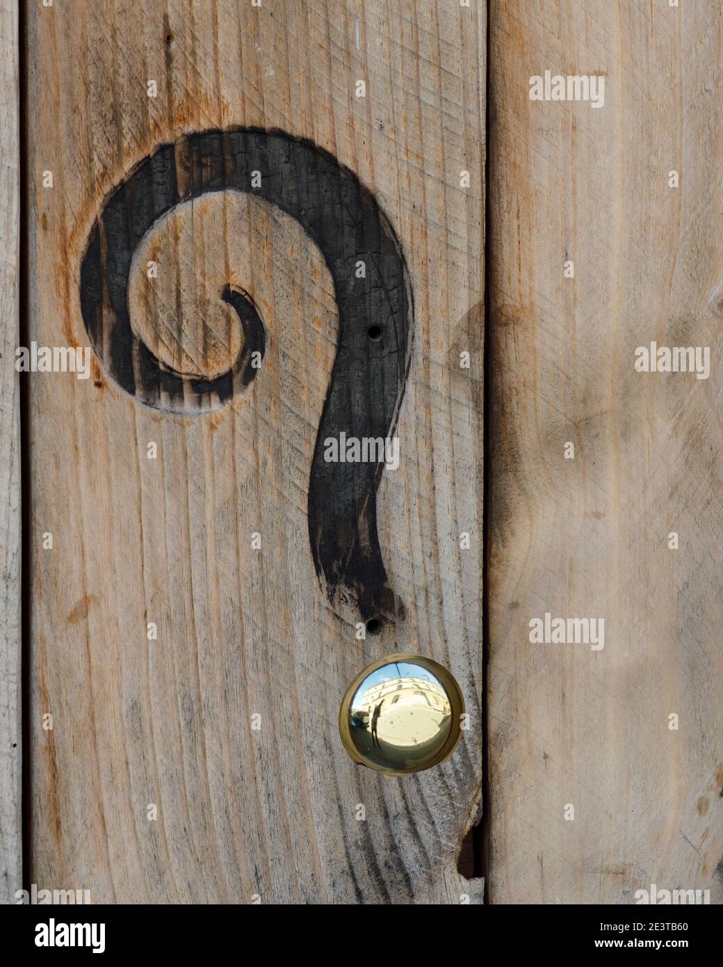 Ein Fragezeichen-Typ-Eindruck auf Holz mit eingebrannter Figur und poliertem Metallstecker. Stockfoto
