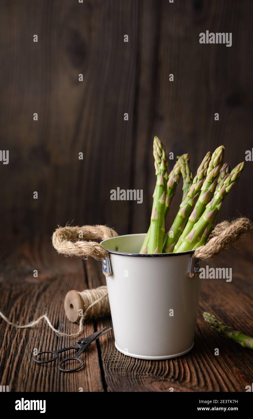 Nahrhaftes Gemüse reich an Antioxidantien, ein Bündel frischer grüner Spargel auf rustikalem Holzhintergrund mit Kopierraum Stockfoto