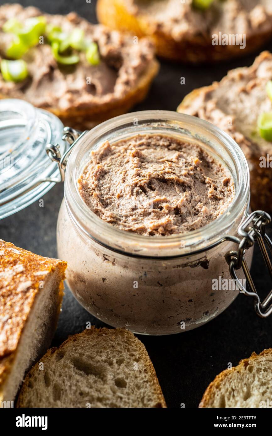 Leberpastete im Glas auf schwarzem Tisch. Stockfoto