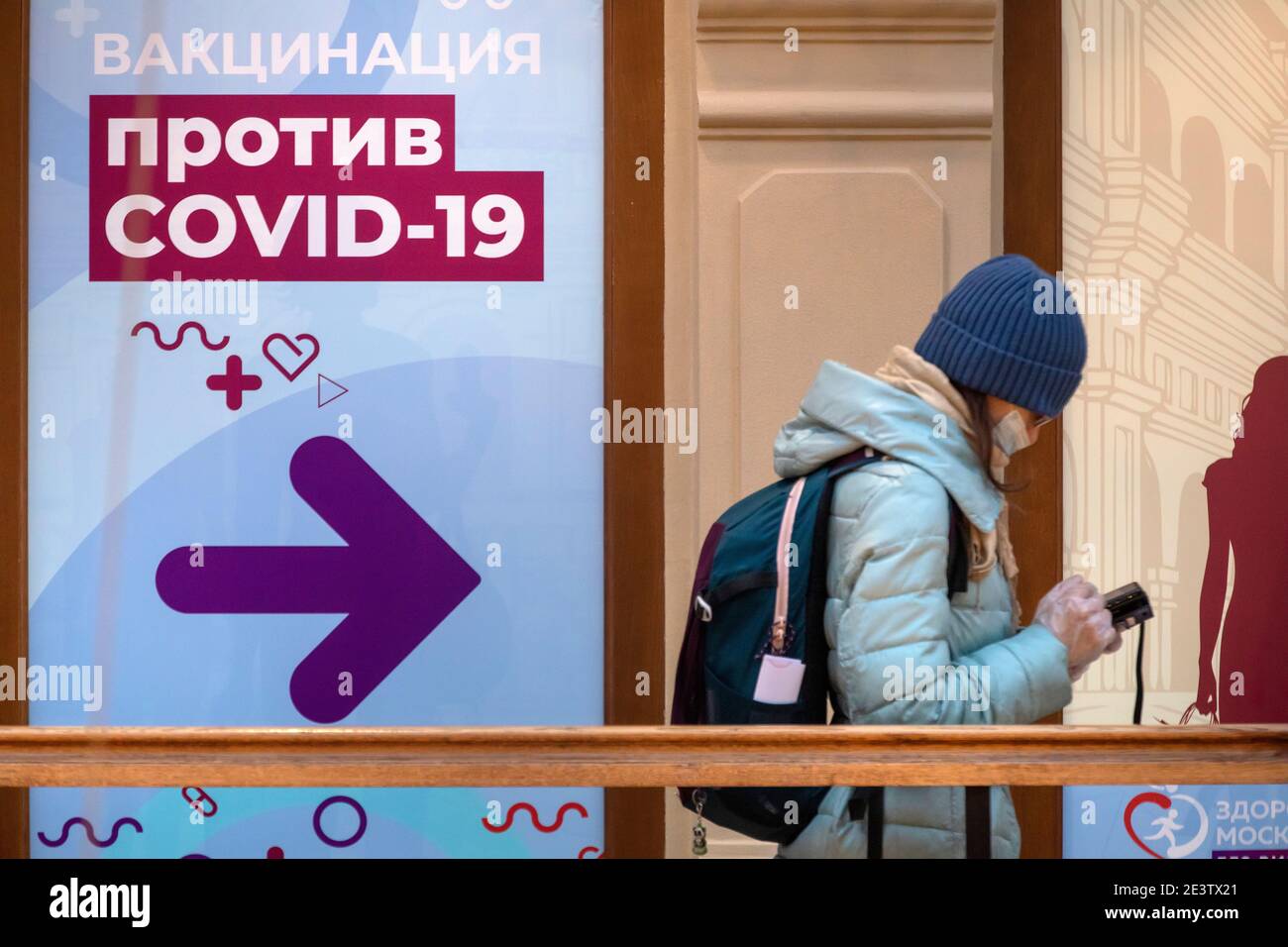Moskau, Russland. 20. Januar 2021 Bürger mit Gesichtsmasken stehen in der Schlange vor einer mobilen Impfeinheit COVID-19 im KAUGUMMI-Kaufhaus im Zentrum von Moskau, Russland. Seit Januar 18 hat Russland mit dem Sputnik V-Impfstoff mit einer Massenimpfung gegen die neuartige Coronavirus-Infektion COVID-19 begonnen. Auf dem Banner steht: „COVID-19-Impfung“ Stockfoto