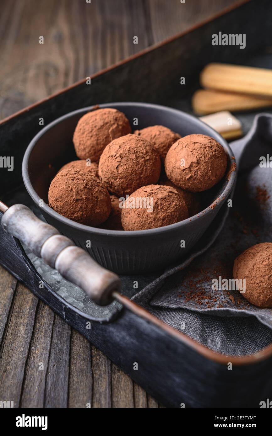 Tiramisu Trüffel in Kakaopulver bedeckt, einfach und schnell keine Backen Dessert aus Mascarpone Käse, Kaffee und Marienkäfer auf rustikalem Holz Stockfoto