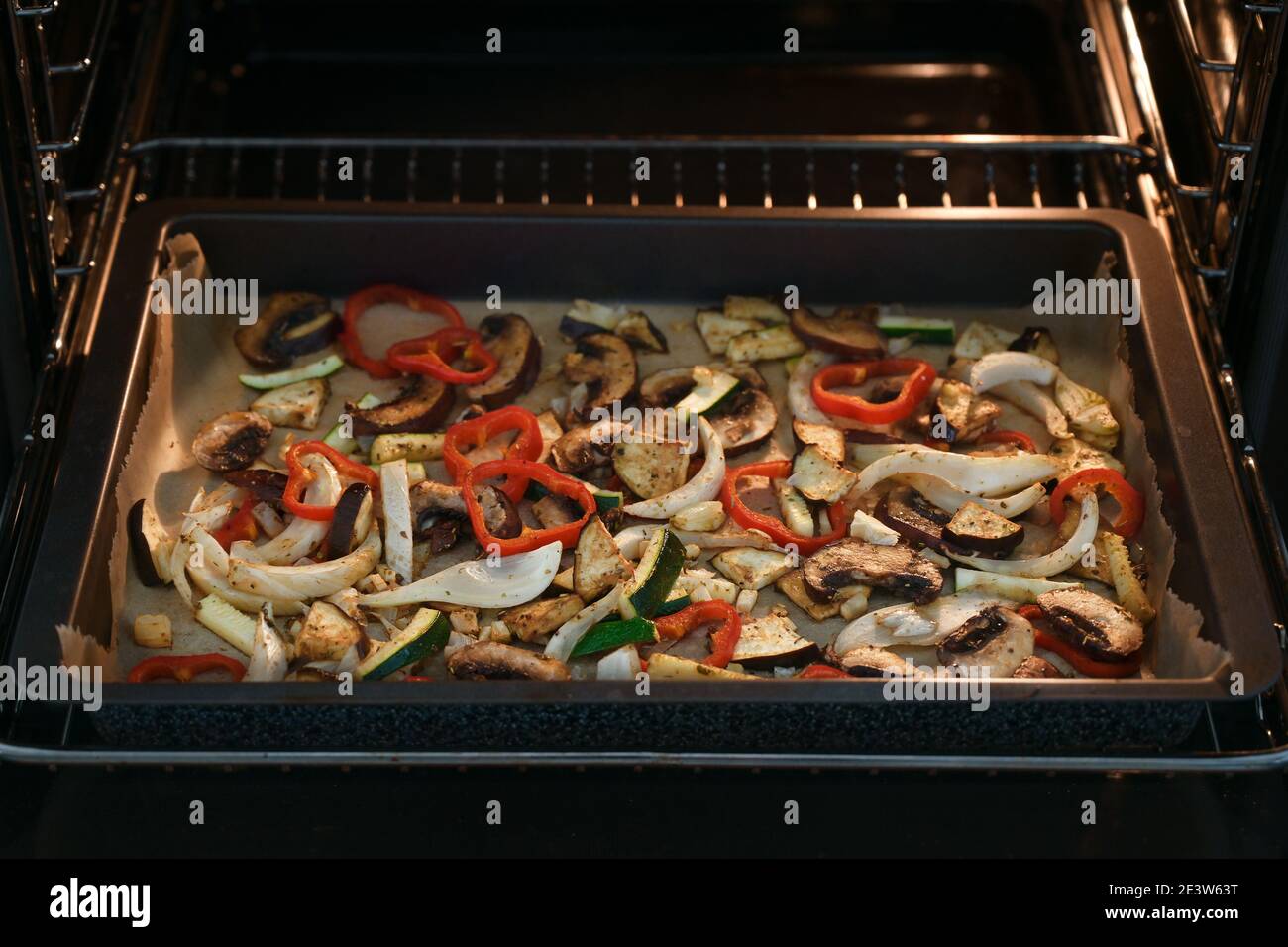 Gemüsescheiben aus Paprika, Pilz, Fenchel, Auberginen und Zucchini auf einem Backblech im Ofen für eine gesunde vegetarische Mahlzeit, Kopierer Platz, Sel Stockfoto