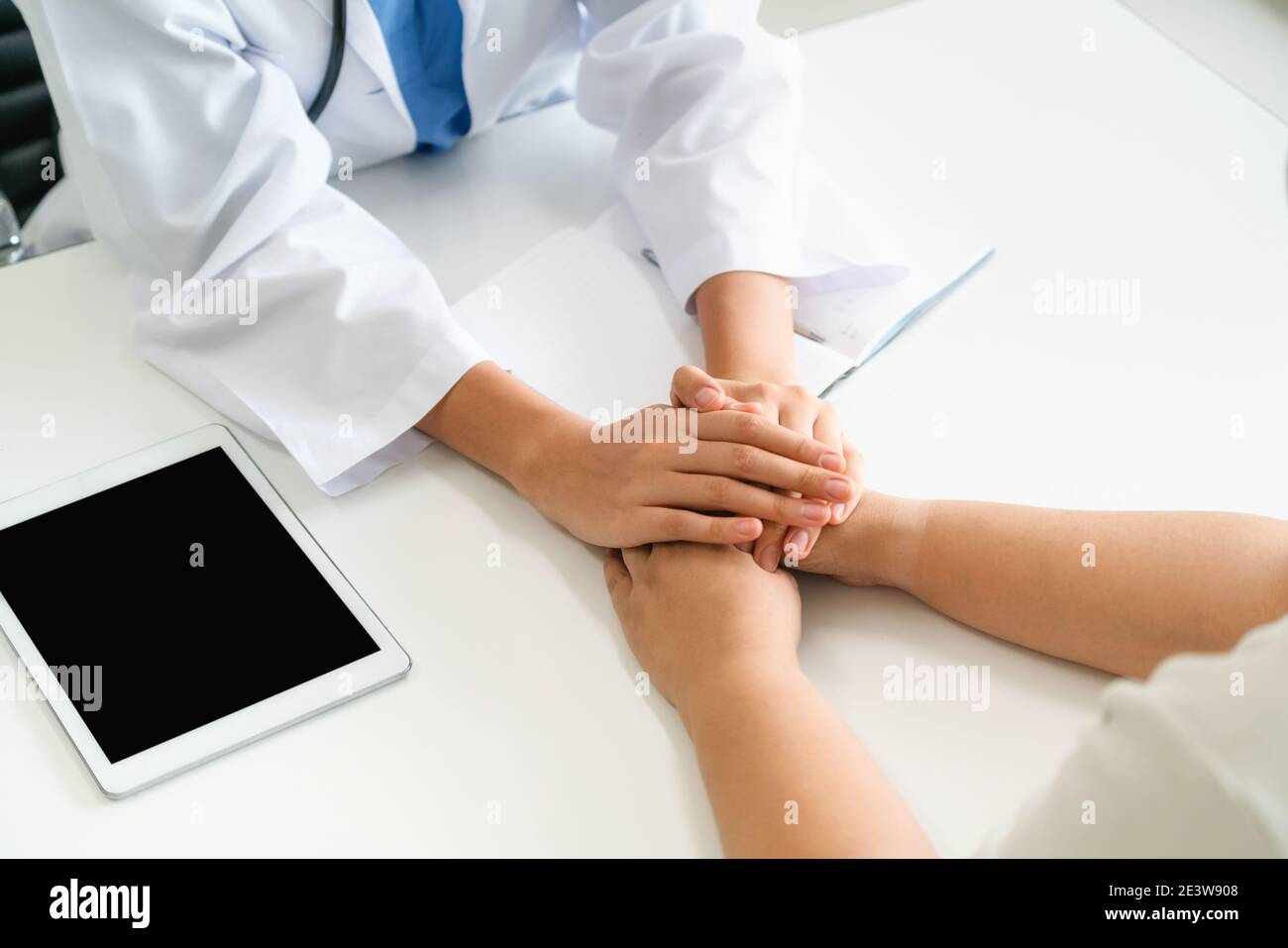 Frau Doktor hält Patienten hand Patient im Zimmer des Krankenhauses. Gesundheitswesen und medizinische Betreuung. Stockfoto