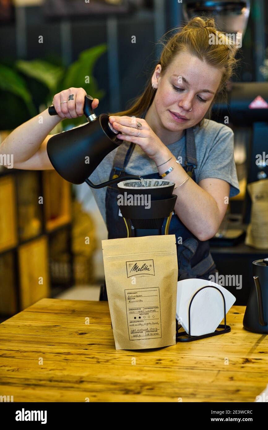 Weibliche Barista gießt Kaffee durch melitta Filter Stockfoto
