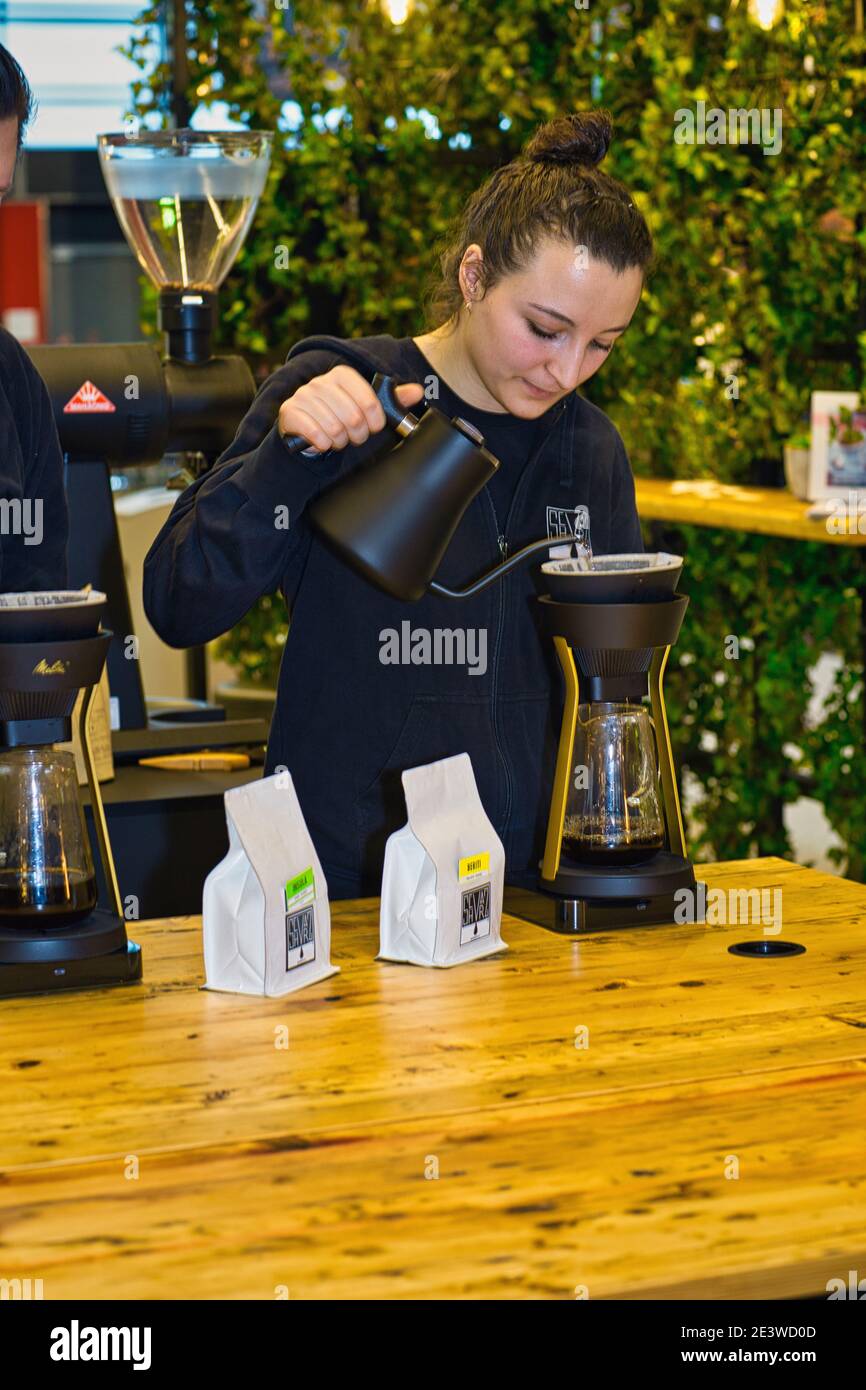 Weibliche Barista gießt Kaffee durch melitta Filter Stockfoto