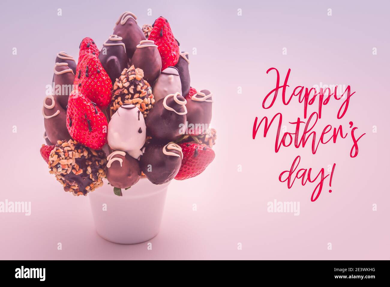 Glückwunschkarte zum Muttertag mit roten Schriftzügen; EIN Bündel essbarer Blumen, Arrangement von in Schokolade getauchten Erdbeeren isoliert auf weißem Hintergrund Stockfoto