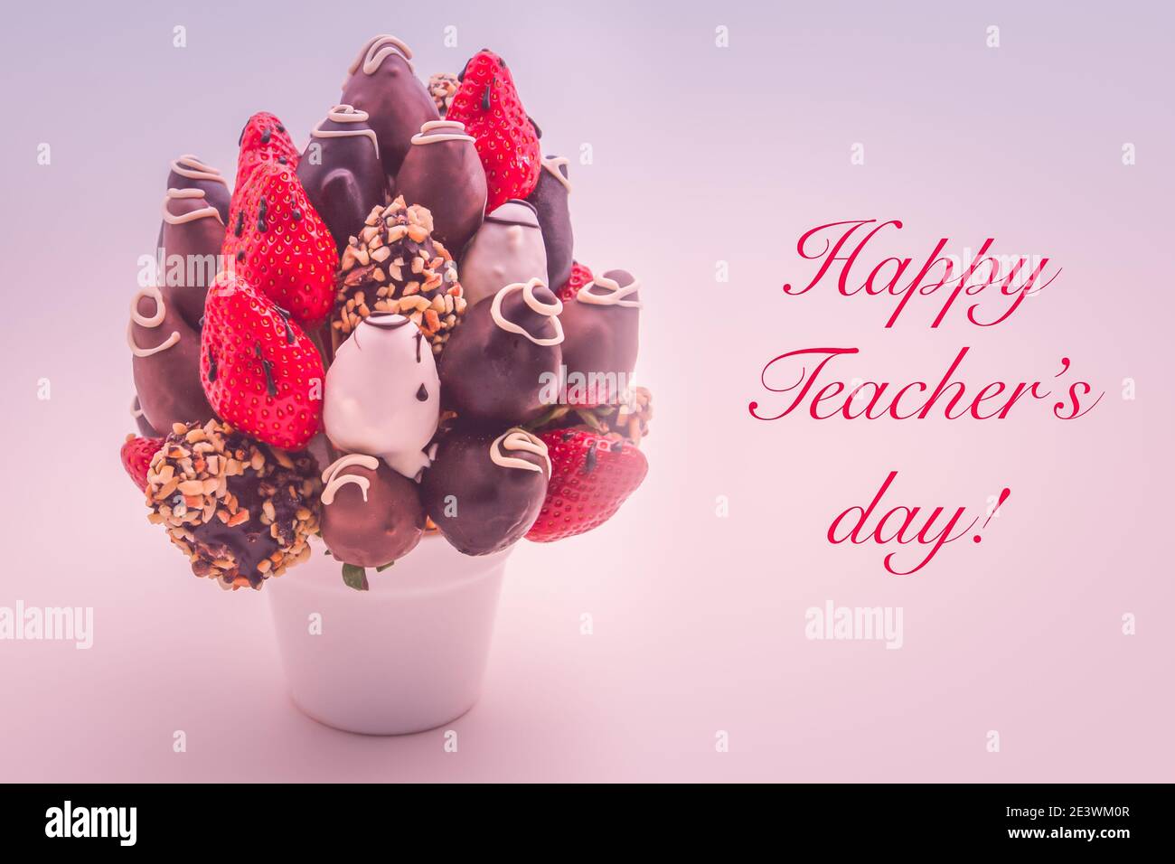 Happy Teacher's Day Grußkarte mit roten Schriftzügen; EIN Strauß essbarer Blumen, Arrangement von in Schokolade getauchten Erdbeeren isoliert auf weißem Hintergrund Stockfoto