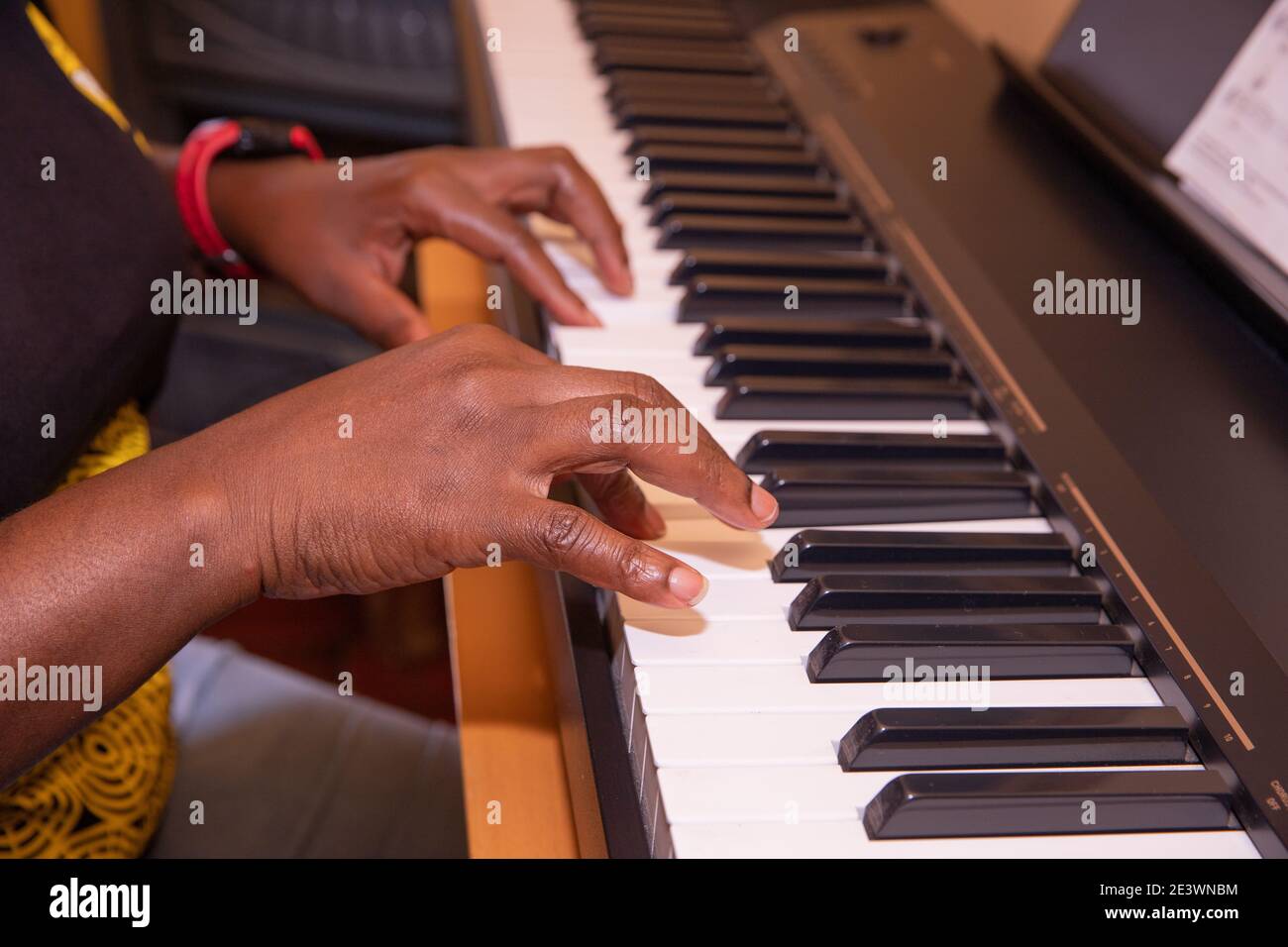Schwarze Frau spielt Klavier in ihrem Wohnzimmer Stockfoto