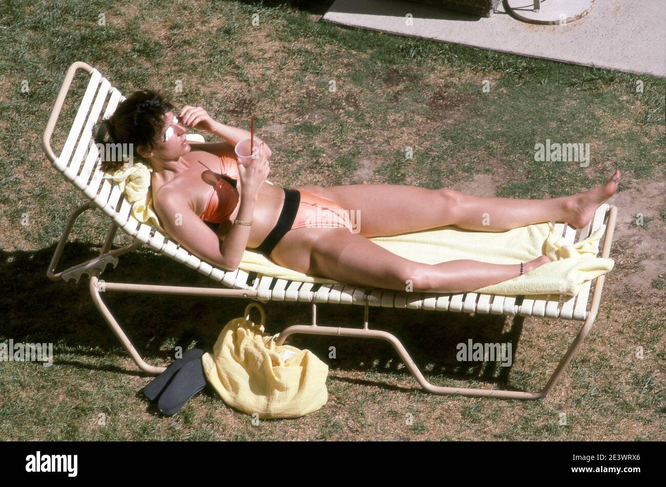 Frau, die sich auf der Liegewiese neben dem Pool im Riviera Hotel in Las Vegas, Nevada um 1990 sonnt. Stockfoto