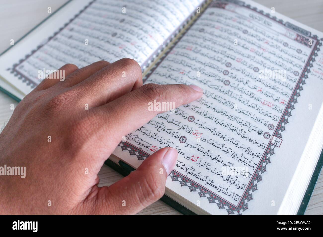 Nahaufnahme der Hand beim Lesen des Heiligen Quran in der Moschee. Selektiver Fokus. Stockfoto