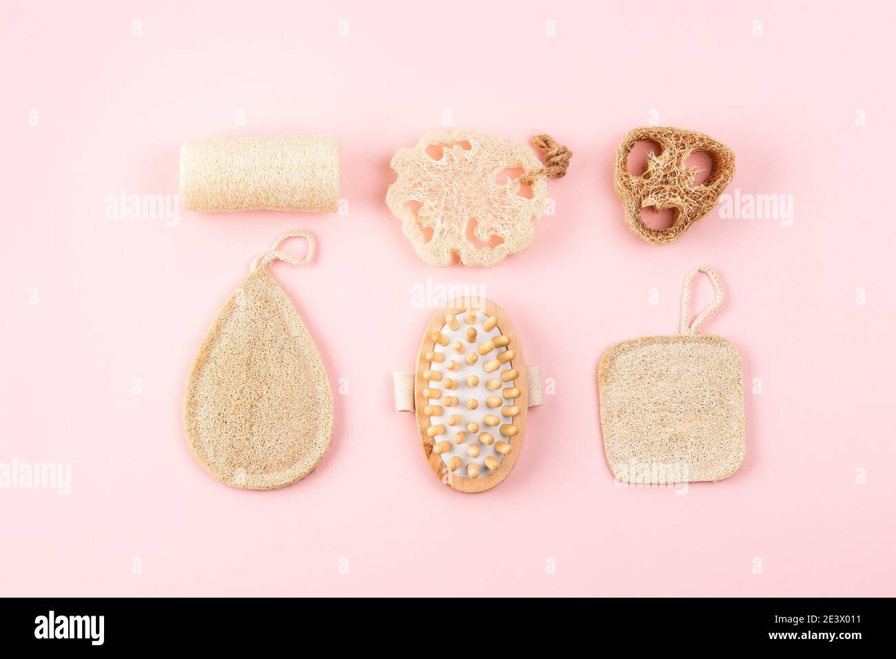 Bad-Accessoires, Naturlöffelschwamm, Holzbürste auf rosa Hintergrund. Zero Waste und plastikfreies Konzept, nachhaltiges Bad und Lifestyle Stockfoto