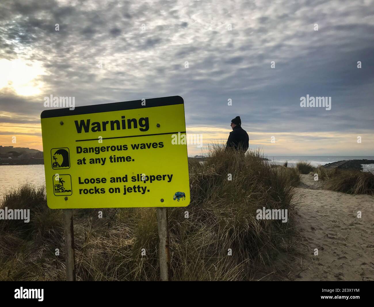 Warnzeichen gefährliche Wellen. Männlicher Tourist in Szene. Stockfoto
