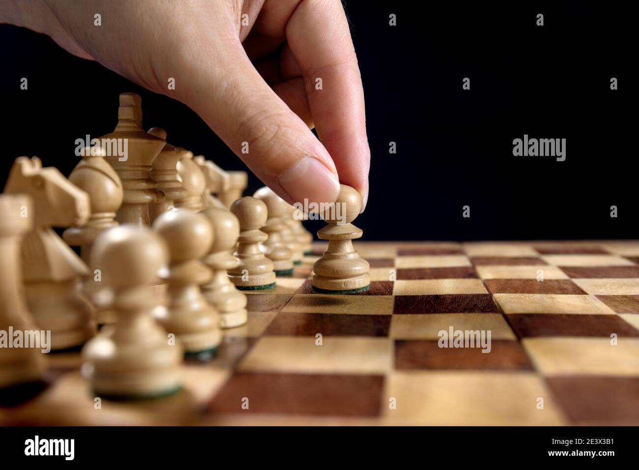 Männliche Hand bewegt die weiße Schachfigur während des Spiels Von Schach Stockfoto