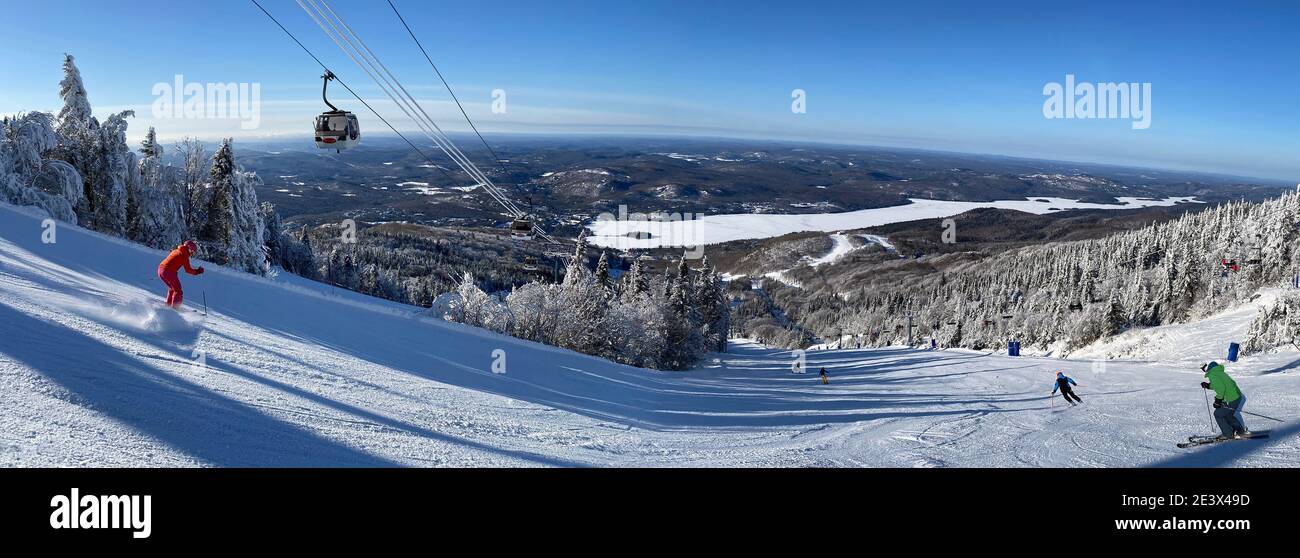Panorama-Luftaufnahme von Mont und Lake Tremblant im Winter mit Skifahrern auf Piste Abfahrt, Quebec, Kanada Stockfoto