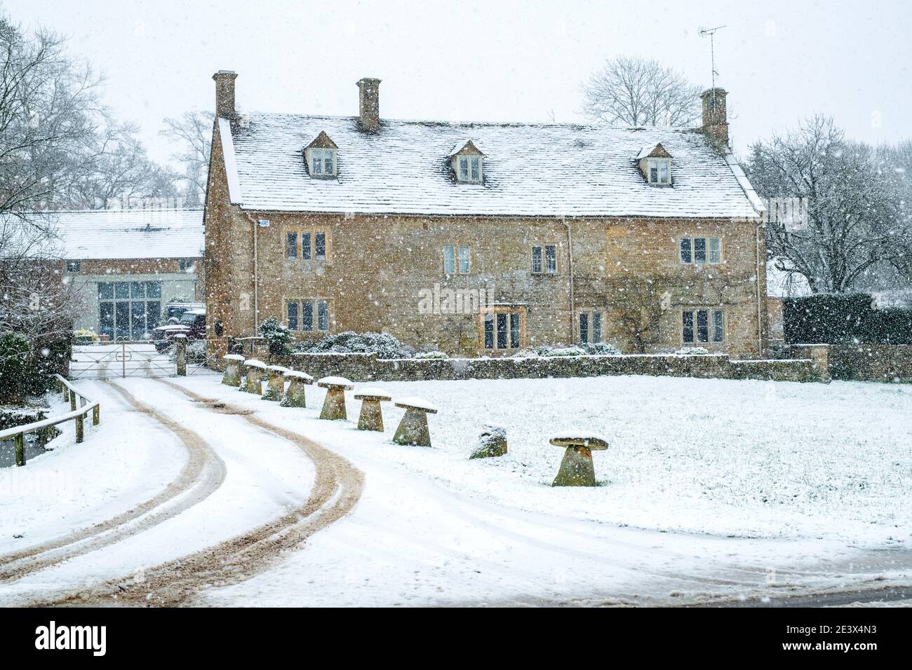 Cotswold Steinhaus im Dezember Schnee. Wyck Rissington, Cotswolds, Gloucestershire, England Stockfoto