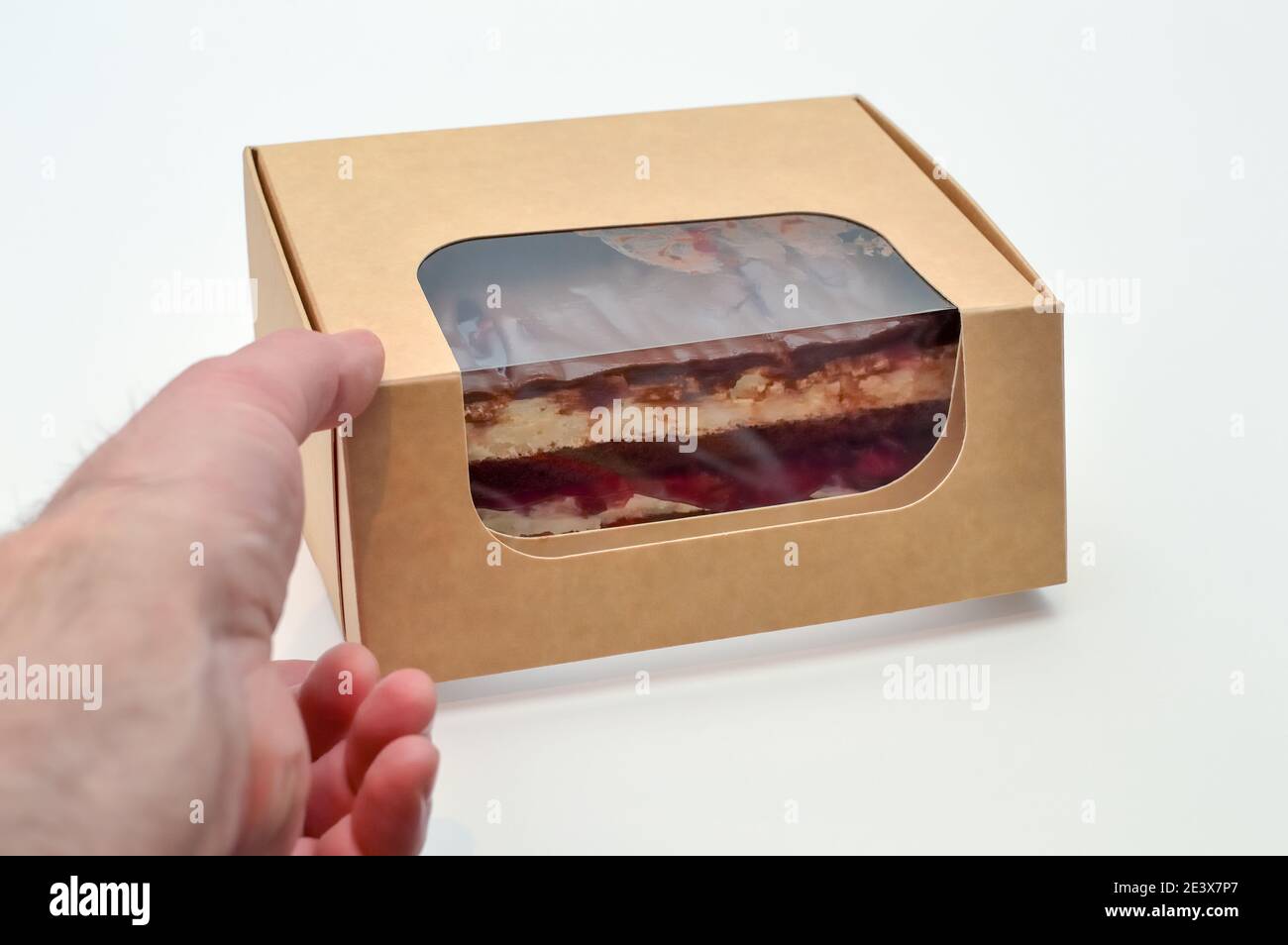 Öffnen einer Einweg-Schutzkarton mit Kuchen nach dem Lieferung von der Bäckerei Stockfoto