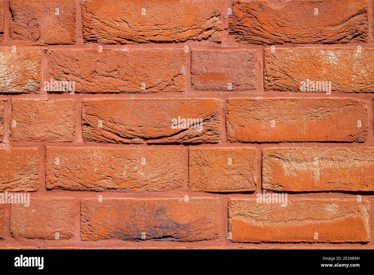 Dekorative orange gemalte Ziegelwand. Reparatur von Innenräumen und Gebäudefassaden. Dekorative Backstein Wand Hintergrund mit Kopierer Platz. Stockfoto