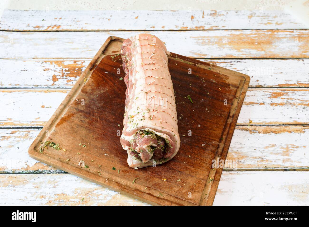 Zubereitung einer Porchetta mit einer Mischung aus aromatischen Kräutern Auf einem Stück frischen Schweinebauch offen in Die Dicke Stockfoto