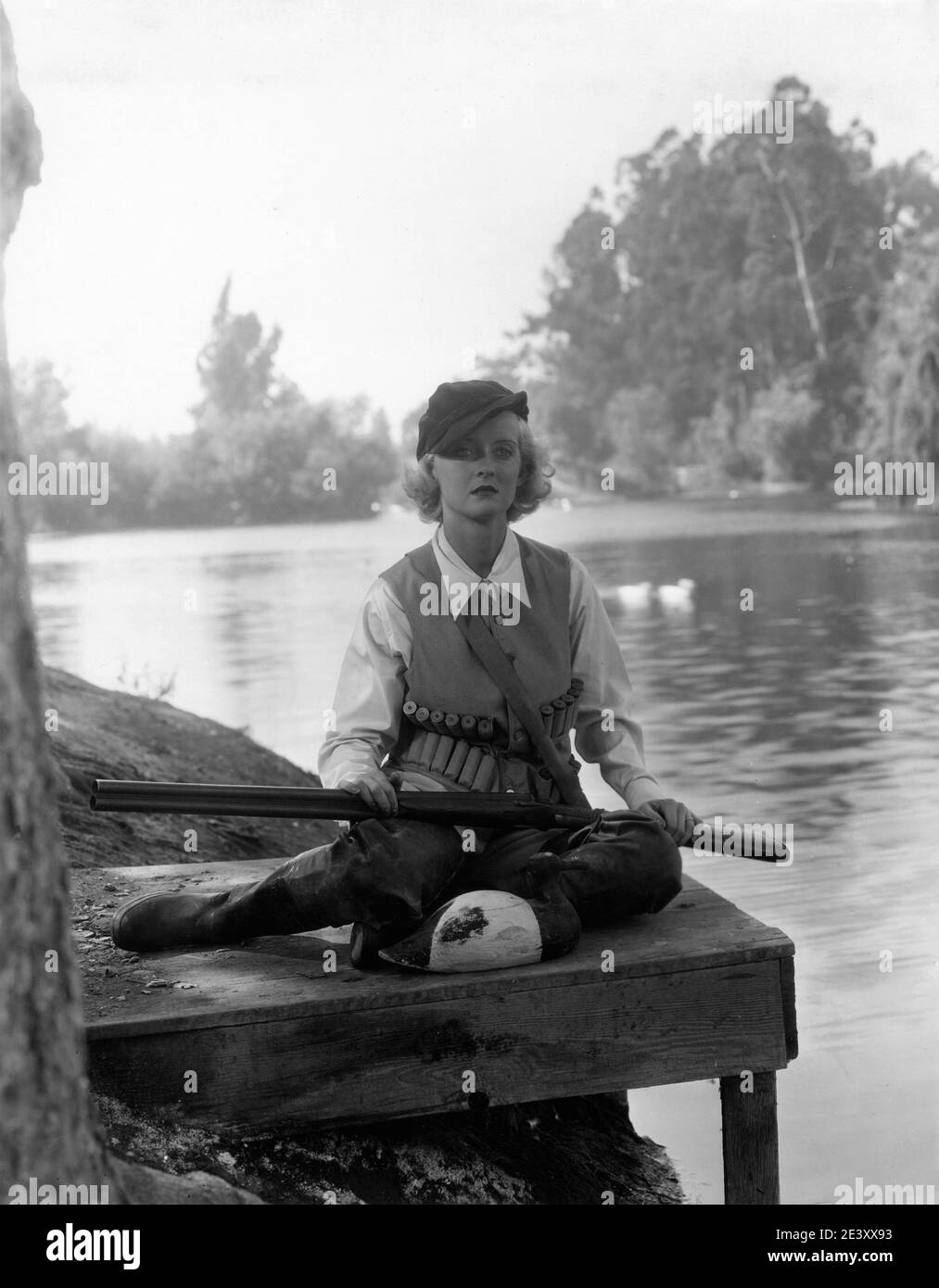 BETTE DAVIS in Duck Hunting Outfit mit Double Barreled Shotgun und Decoy ca. 1933 Werbepose für Warner Bros. Stockfoto