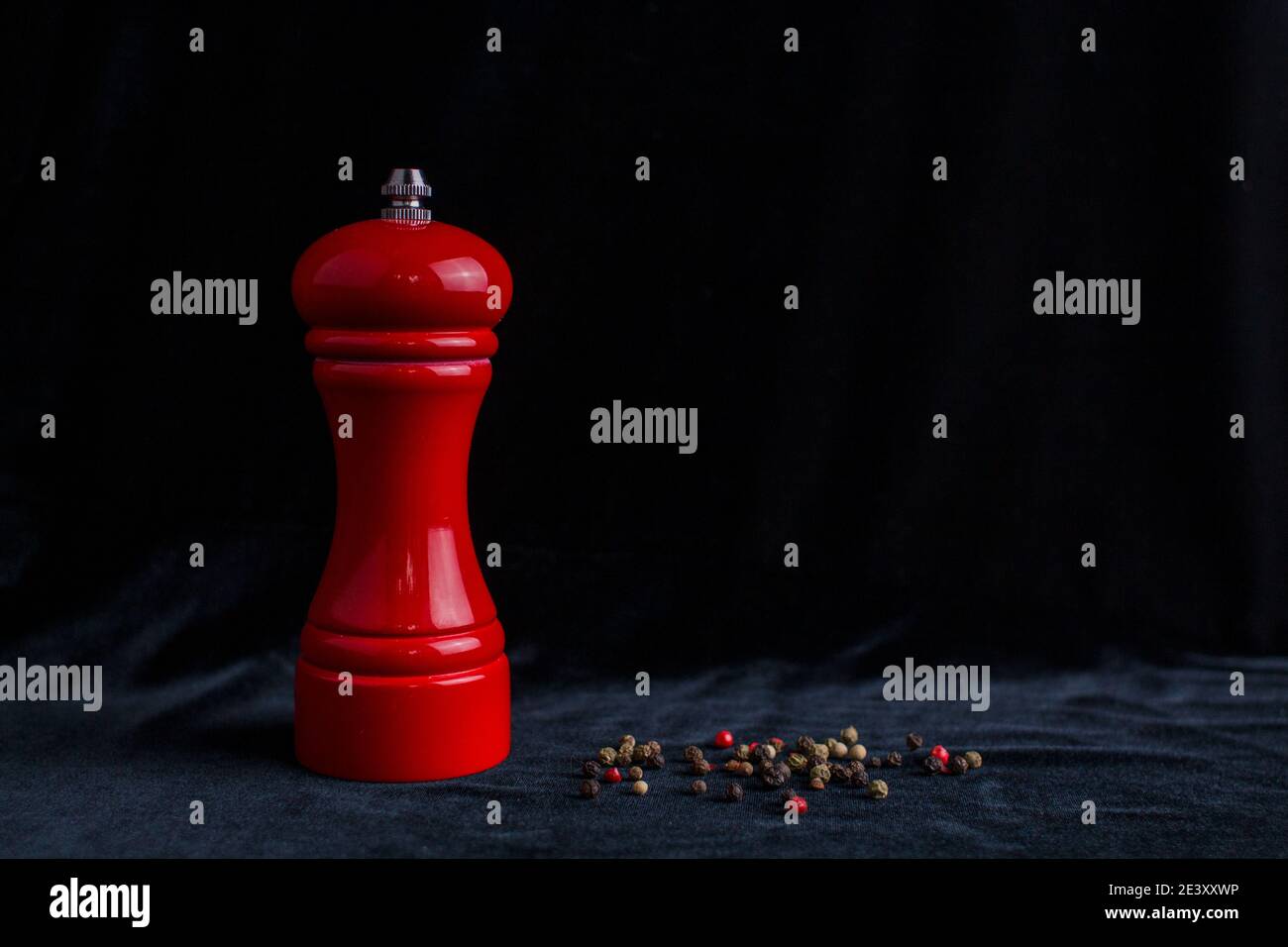 Ein roter Pfefferstreuer auf schwarzem Hintergrund in der Küche Stockfoto