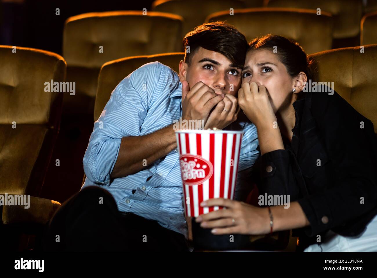 Ein paar Liebhaber, die im Kino Filmschocks und Augen sehen, schließen sich. Stockfoto