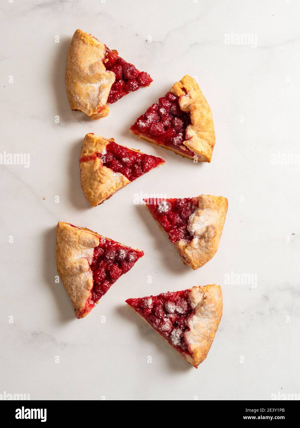 Perfekte Scheiben Himbeer Galette. Köstliche rustikale hausgemachte Tarte mit gefrorenen oder frischen Himbeeren, weißem Marmor Hintergrund. Schöne Galette Stücke mit Himbeeren, kopieren Raum. Draufsicht, flach liegend Stockfoto