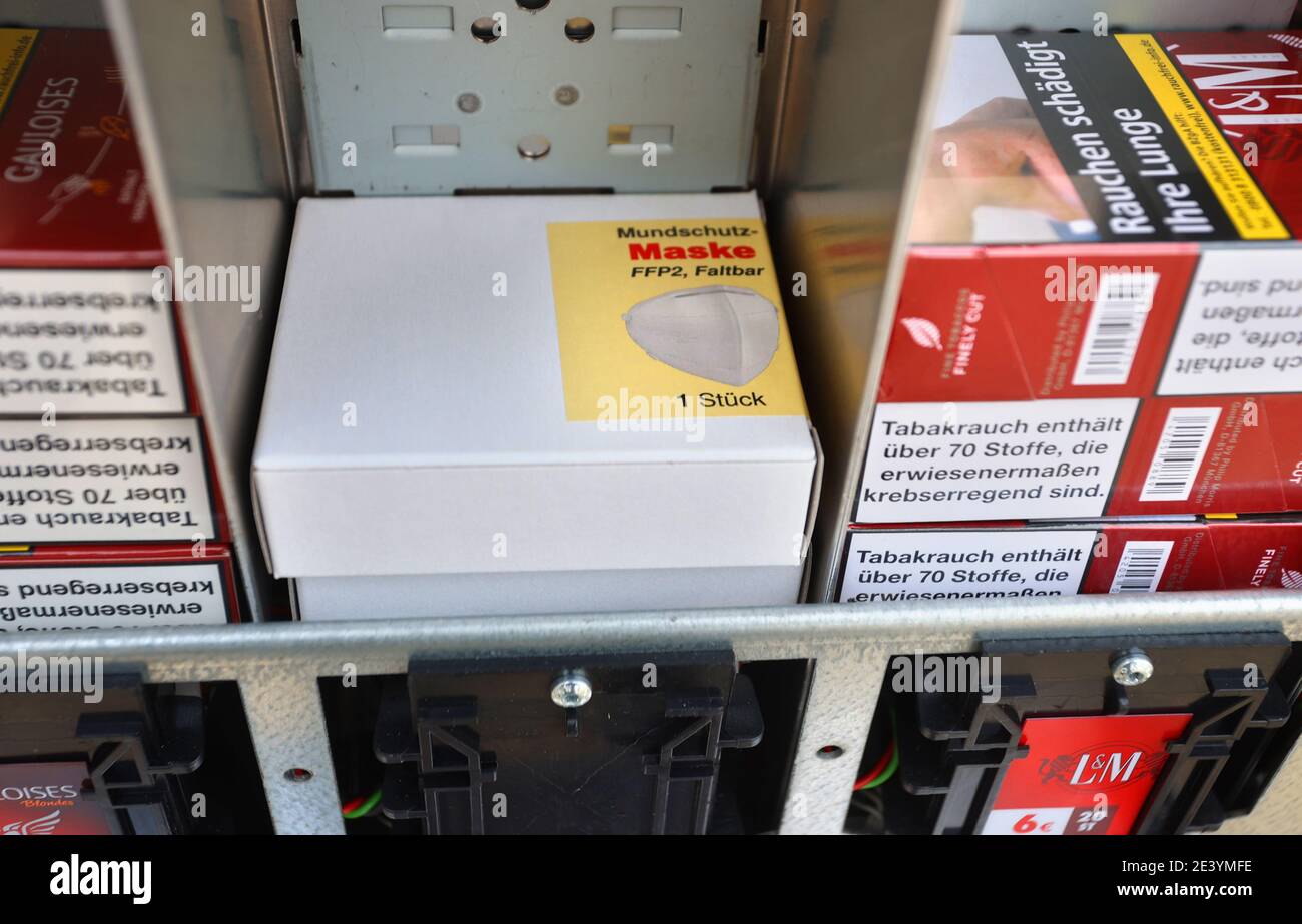 Gerolzhofen, Deutschland. Januar 2021. Eine Packung FFP2-Masken liegt zwischen Zigarettenpackungen in einem Zigarettenautomaten. Ein Tabakladen bietet die Schutzmasken in seinen Automaten an. Quelle: Karl-Josef Hildenbrand/dpa/Alamy Live News Stockfoto