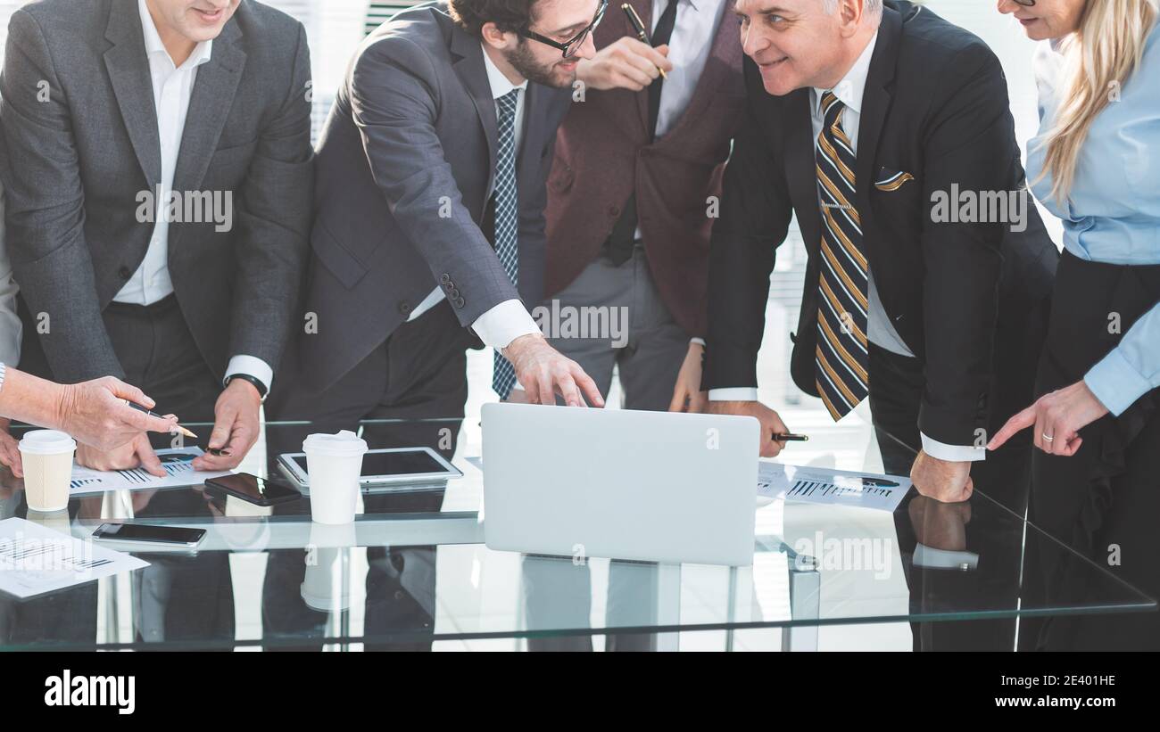 Gruppe von Mitarbeitern, die begeistert auf den Laptop-Bildschirm schauen Stockfoto