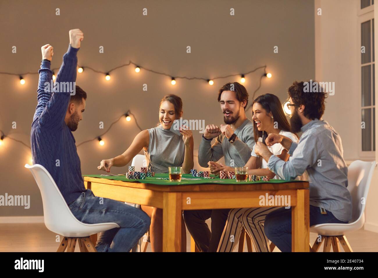 Junge glückliche Freunde spielen Brettspiele auf dem Tisch zu Hause Und Spaß haben Stockfoto