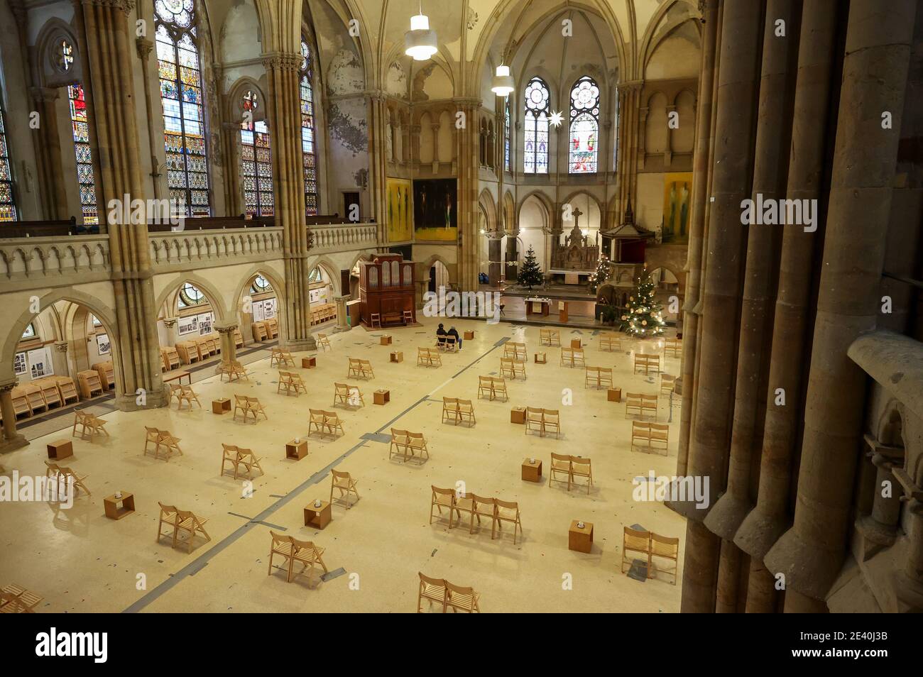 Leipzig, Deutschland. Januar 2021. Zwei Personen sitzen in der St. Peter's Church, die Corona-Sitzgelegenheiten mit nur wenigen Stühlen hat. Das öffentliche Leben bleibt bis zum 14. Februar 2021 geschlossen. Es ist immer noch möglich, Gotteshäuser zu besuchen. Die St. Peter Kirche ist täglich geöffnet und die Gottesdienste werden online übertragen. Quelle: Jan Woitas/dpa-Zentralbild/dpa/Alamy Live News Stockfoto