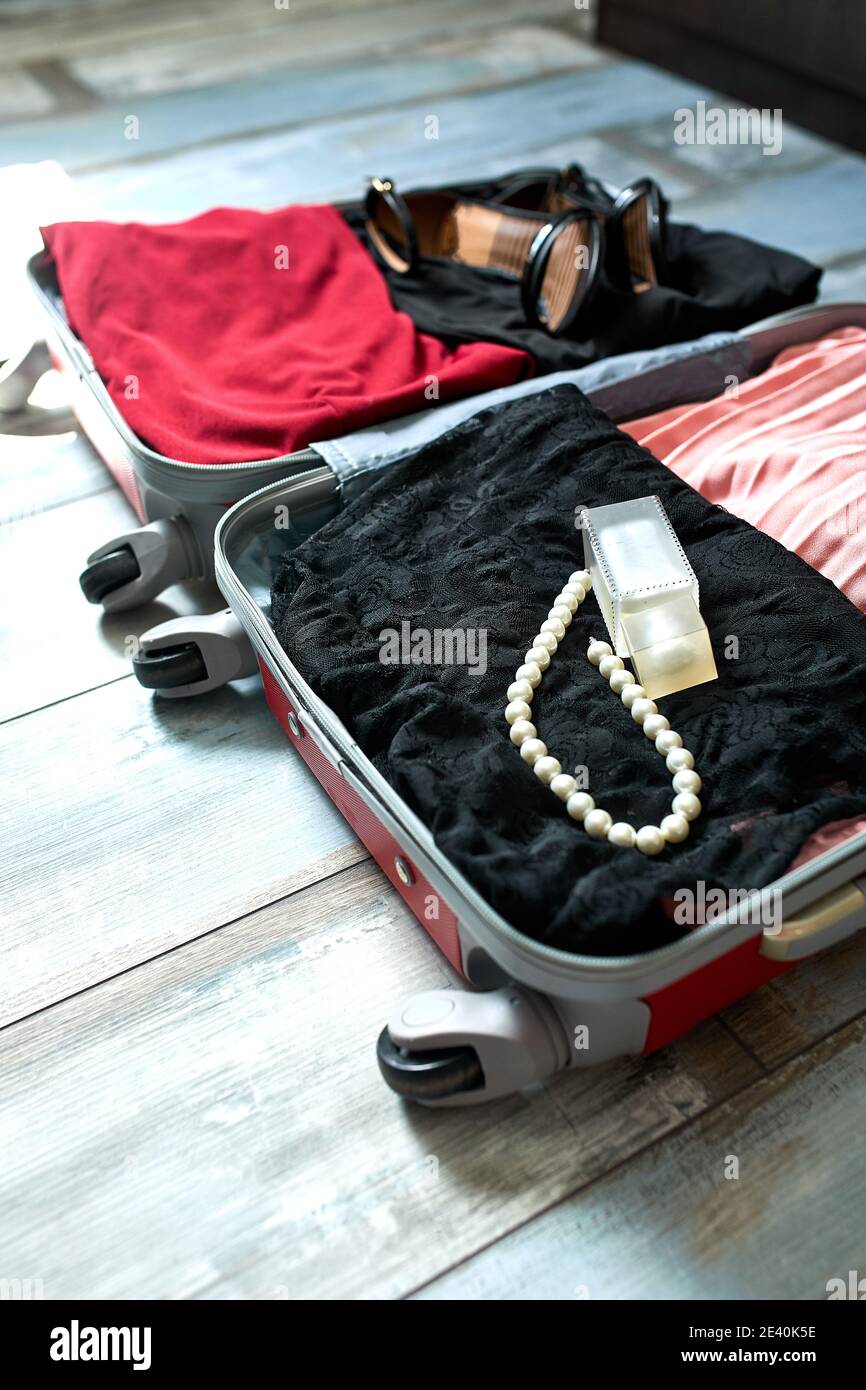 Verpackung Koffer zu Hause mit Frau Artikel, Zubehör im Koffer für Reisen, Reise, Urlaub. Speicherplatz kopieren. Stockfoto