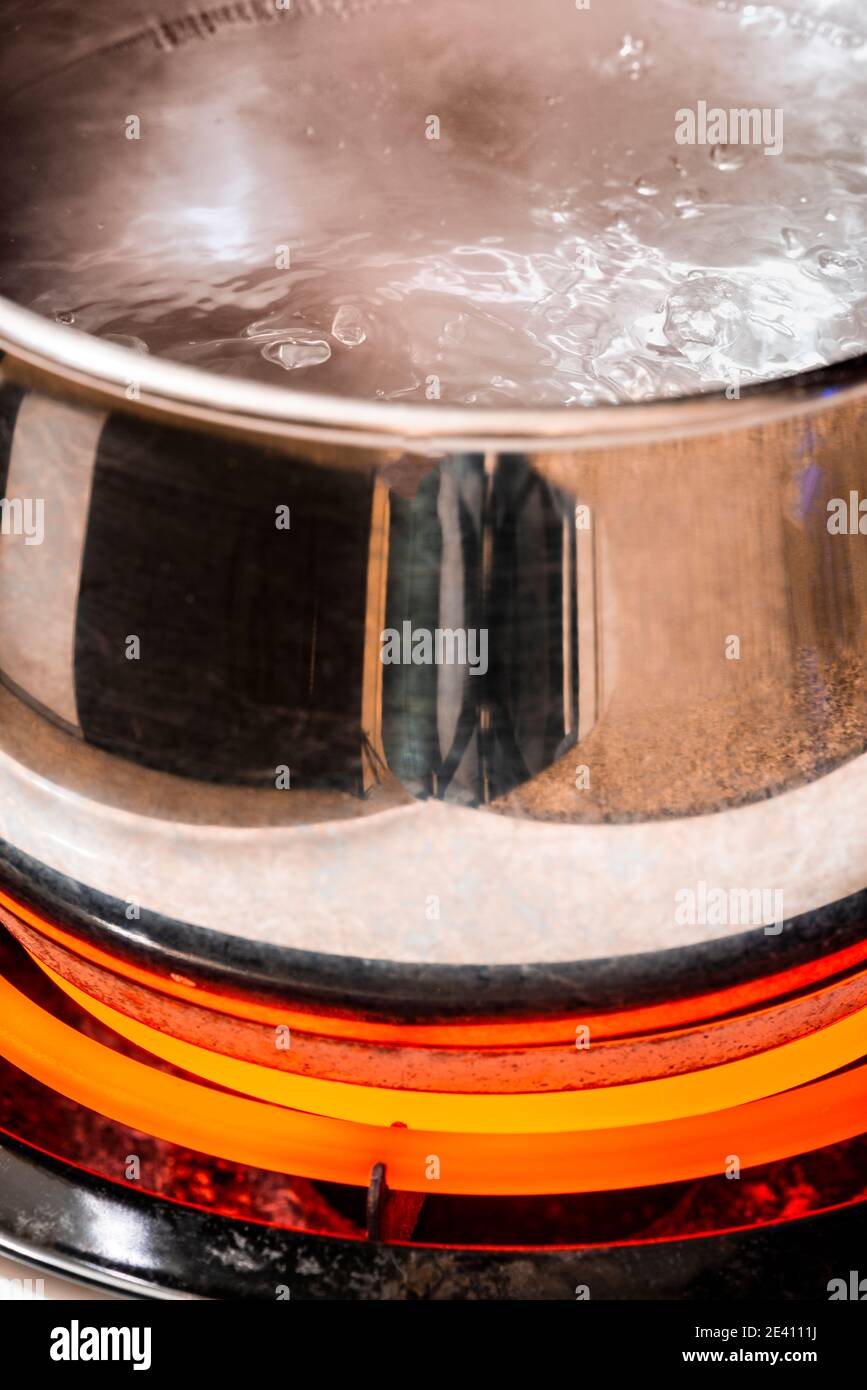 Nahaufnahme der vertikalen Aufnahme eines Topfes kochendes Wasser auf einem Brenner auf hoch. Stockfoto