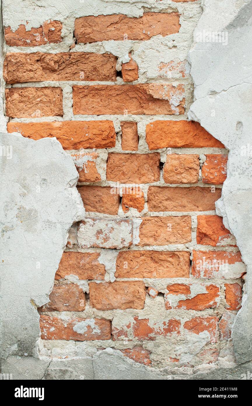 Gesprungene Wandstruktur Aus Altem Ziegelstein. Lackierte Verdrängte Oberfläche. Grungy Breite Ziegelwand. Grunge Red Stonewall Hintergrund. Schäbige Gebäudefassade Mit Stockfoto