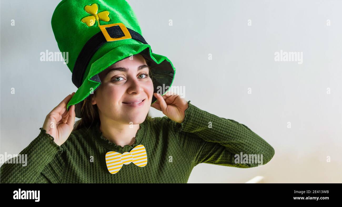 Lächelnde junge Frau in einem Gewächshaus - St. Patrick Day Urlaub Stockfoto